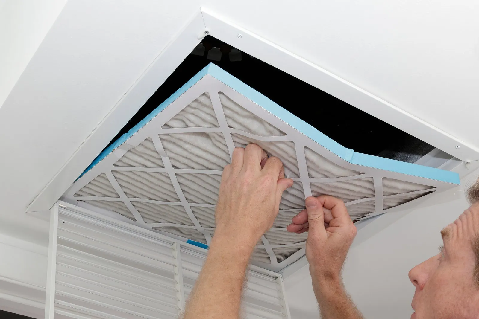 Technician cleaning an air duct vent in a Everett home